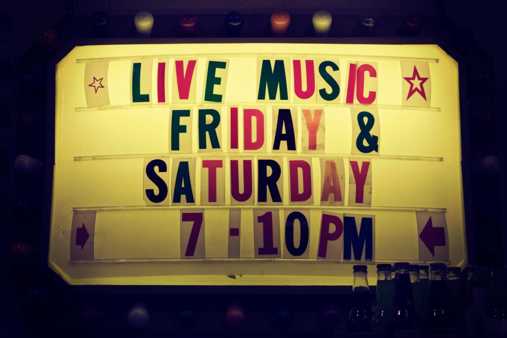 Illuminated vintage marquee promoting live music nights on Friday and Saturday.
