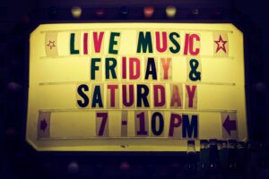 Illuminated vintage marquee promoting live music nights on Friday and Saturday.